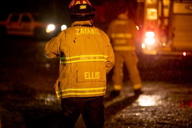 Zayante firefighter at night with water drops falling from the sky