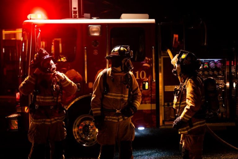Firefighters in front of a truck at night