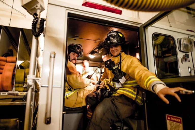Firefighters smiling from inside of a truck
