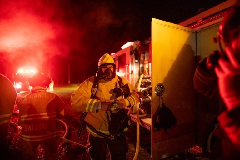 Firefighters near a truck at night