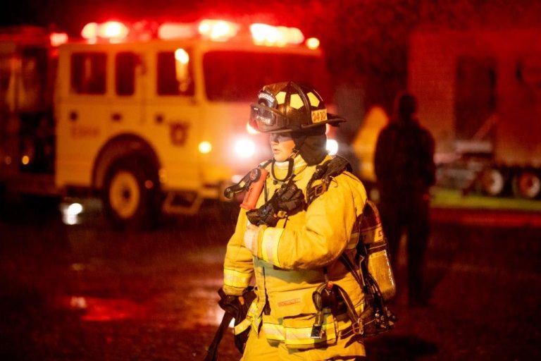 Firefighter in front of a truck at night